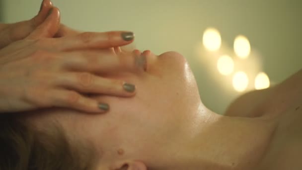 the woman doing the facial massage - Materiał filmowy, wideo