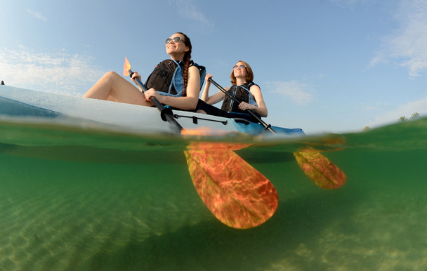 giovani donne sorridenti mentre fanno kayak nell'oceano
 - Foto, immagini