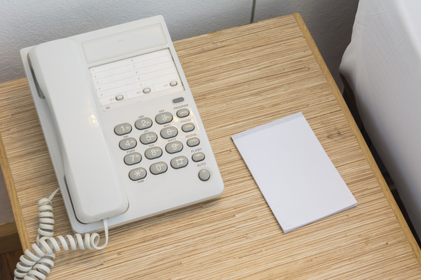 O telefone na mesa com um caderno de papel e um lápis. No...
  - Foto, Imagem