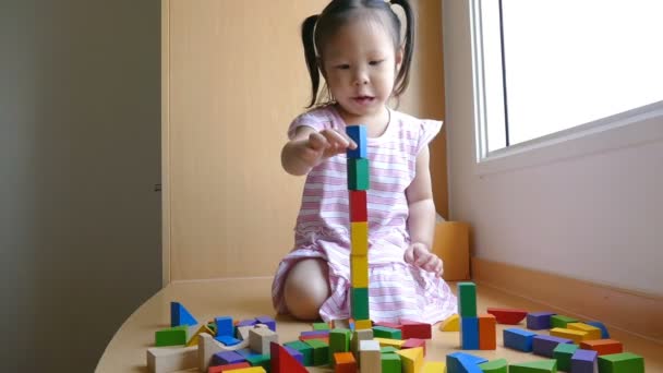 Chica jugando con bloques de madera
 - Metraje, vídeo