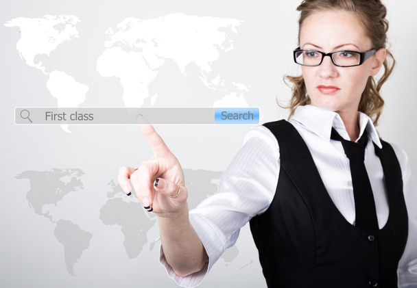 first class written in search bar on virtual screen. Internet technologies in business and home. woman in business suit and tie, presses a finger on a virtual screen - Photo, Image