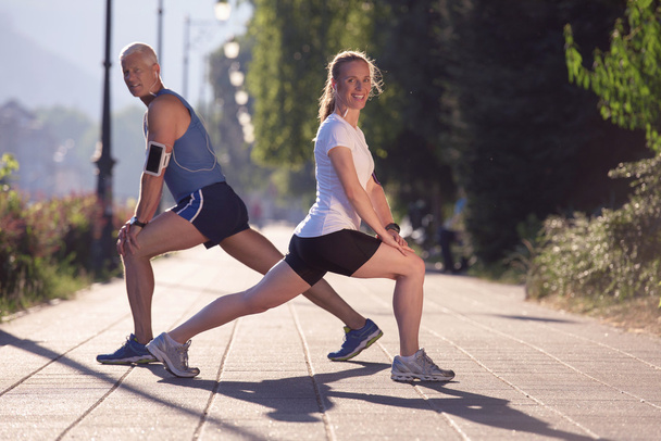 couple warming up and stretching before jogging - Foto, Imagen