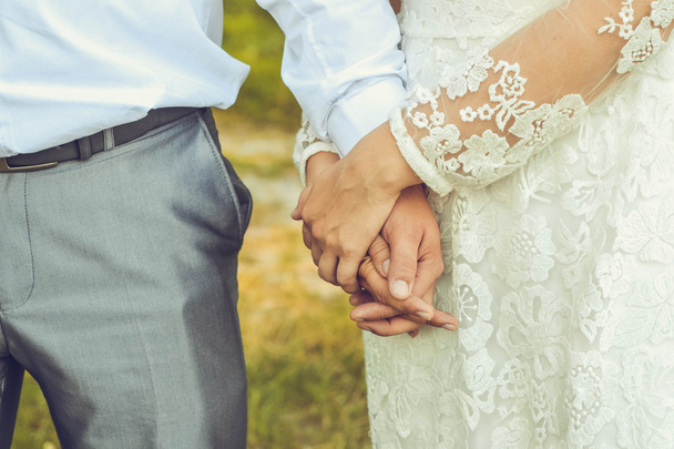 Γαμπρός την νύφη κρατώντας τα χέρια closeup - Φωτογραφία, εικόνα