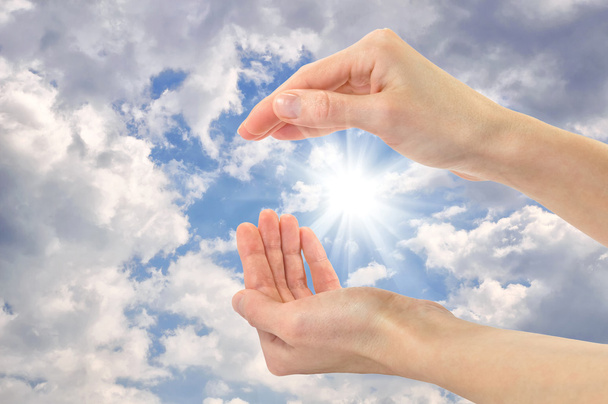 Руки людини на тлі сонячного хмарного неба
 - Фото, зображення