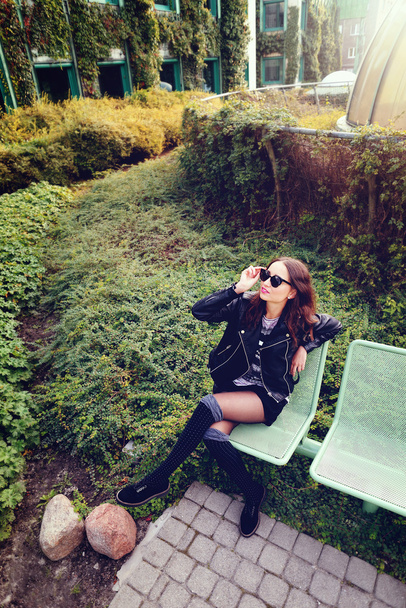 fashion model in sunglasses and black leather jacket posing outdoor - Foto, Imagem