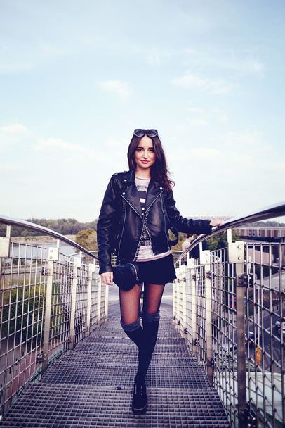 fashion model in sunglasses and black leather jacket posing outdoor - Foto, afbeelding