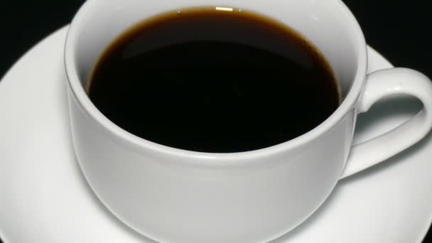 Taza blanca café negro sobre fondo negro
 - Metraje, vídeo