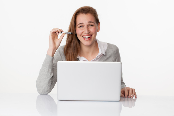 laughing 20s girl working at her desk with satisfaction - Foto, Imagen