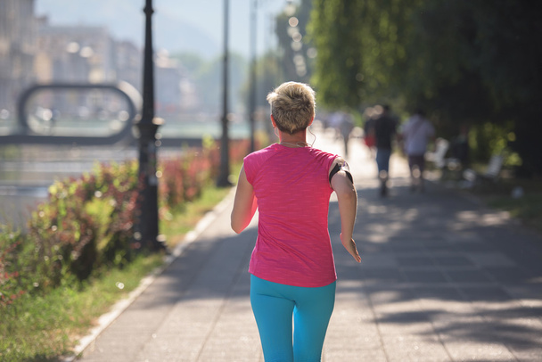 sporty woman running  on sidewalk - Фото, изображение