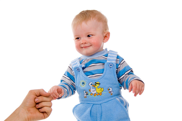 A small child is held by the hand of the parents - Фото, изображение