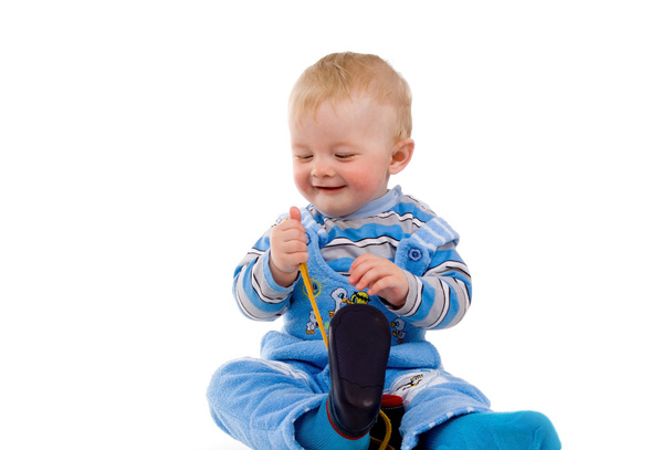 A small child trying to dress up shoes - Foto, Bild
