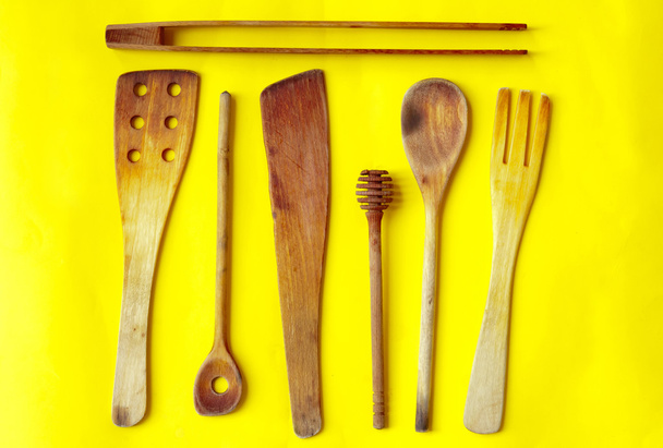 Старі дерев'яні ложки і мішалки на жовтому тлі
 - Фото, зображення