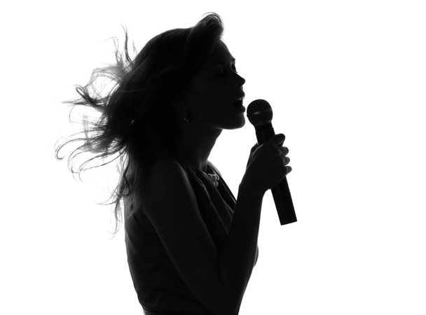 silhouette of a woman singing with a microphone - Foto, afbeelding