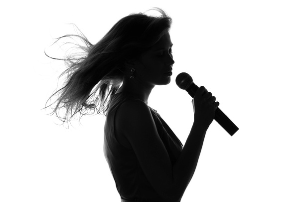 silhouette of a woman singing with a microphone - Photo, image