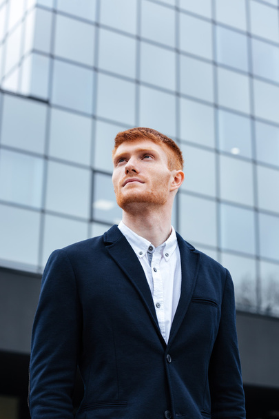 Pensive businessman standing outdoors - Fotoğraf, Görsel