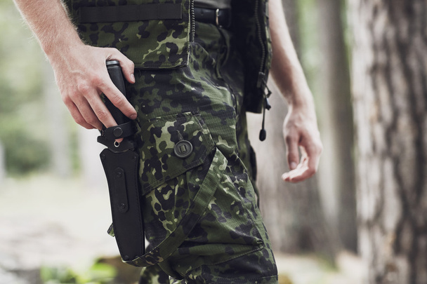 close up of soldier or hunter with knife in forest - Foto, afbeelding