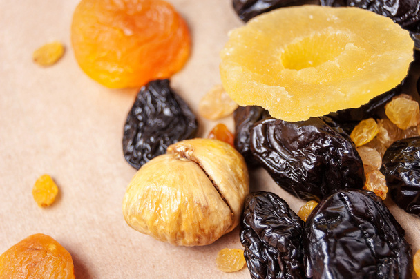 dried fruits, dried pineapple, dried figs, walnuts, prunes, figs, dried apricots on a paper, top view  - Фото, зображення