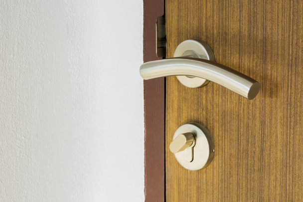 manija de la puerta inoxidable en puerta de madera
 - Foto, Imagen