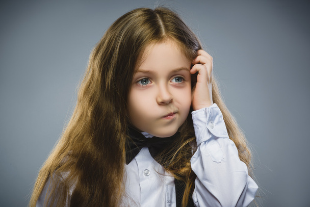 Closeup Thoughtful Young girl Looking Up with Hand at Face isolated on Gray Background - Photo, Image