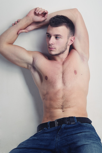 Young handsome guy posing in a studio with a beautiful body - Photo, Image