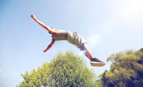 σπορ νεαρός άνδρας άλματα στο πάρκο καλοκαίρι - Φωτογραφία, εικόνα