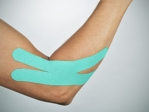 junger Mann mit elastischem Therapieband im Arm - Foto, Bild
