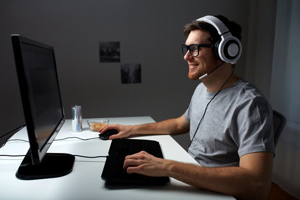 man in headset playing computer video game at home - Foto, Bild