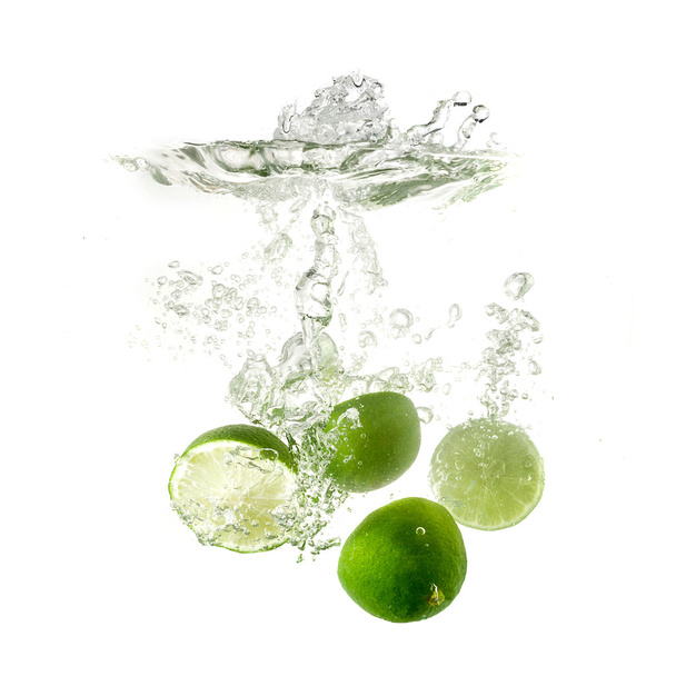 Limes éclaboussent sur l'eau, isolés sur fond blanc
. - Photo, image