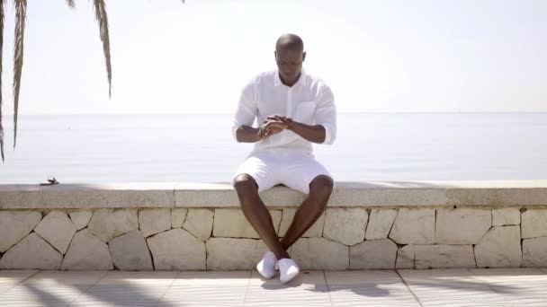 model sitting near sandy beach and ocean - Materiał filmowy, wideo