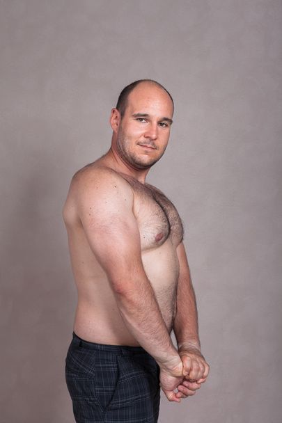 Мужчина без рубашки показывает свои трицепсы и сильное тело
 - Фото, изображение