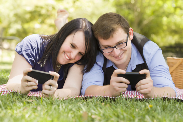 Young Couple at Park Texting Together - Photo, Image