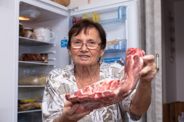 生の豚肉の肋骨を持つ幸せな年配の女性 - 写真・画像