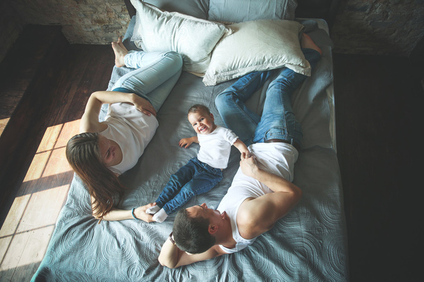 Donne incinte con il marito e la figlia sul letto
 - Foto, immagini