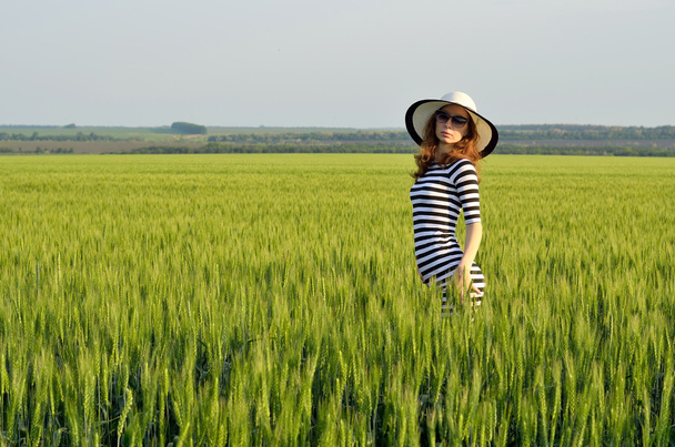 Κομψό νεαρή γυναίκα σε γυαλιά ηλίου και το καπέλο του καλοκαιριού. - Φωτογραφία, εικόνα