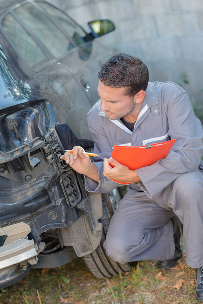 Mechanic inspecting damaged car - Zdjęcie, obraz