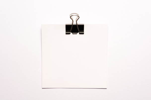 White note paper and black paperclip - Foto, Bild