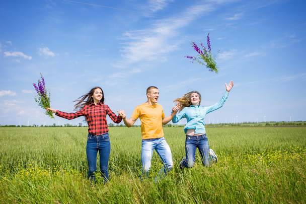 Jeunes amis heureux fonctionnant sur le champ de blé vert
 - Photo, image