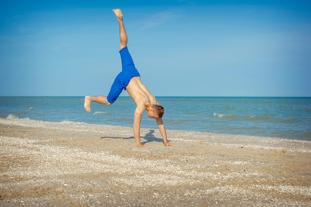 Young man jumping on beach - Zdjęcie, obraz