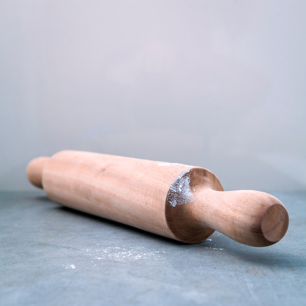 Kitchen rolling pin with flour on dark background selective focus - Фото, зображення