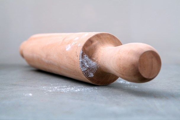 Kitchen rolling pin with flour on dark background selective focus - Фото, зображення