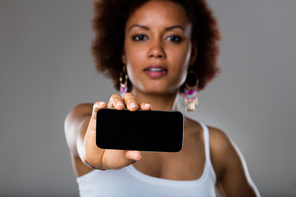 mujer afroamericana mostrando teléfono móvil
 - Foto, imagen