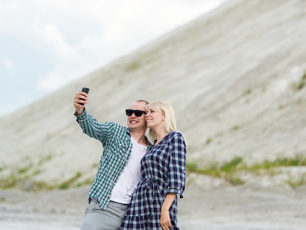 A férfi és a nő lefényképezni magukat. Selfie a szabadban. - Fotó, kép