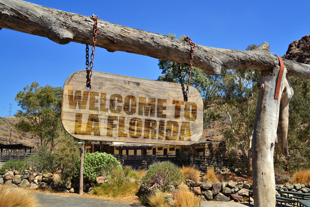 old vintage wood signboard with text " welcome to La Florida" hanging on a branch - Photo, Image