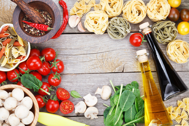 Свежие ингредиенты для приготовления пищи: макароны, помидоры и специи
 - Фото, изображение