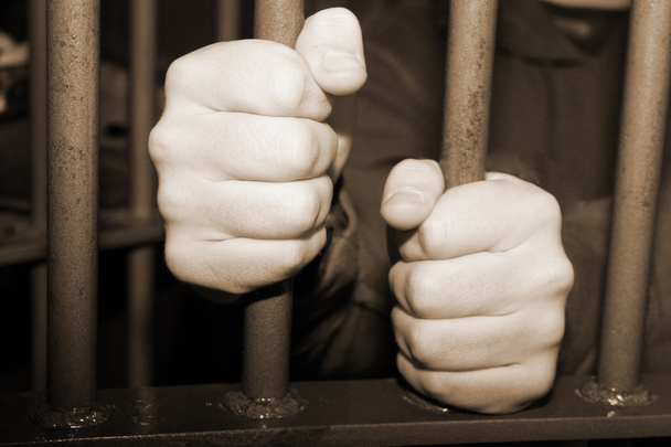 Man's hands behind metal bars - Photo, Image