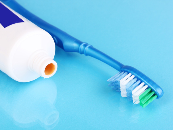 Toothbrush and paste on blue background - Φωτογραφία, εικόνα