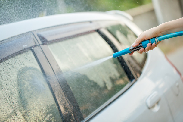 People cleaning car using high pressure water - Foto, afbeelding