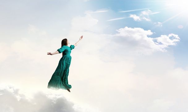 Vrouw in bewolkte hemel - Foto, afbeelding