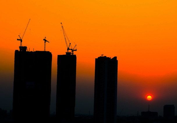 Силуэт строительной площадки на фоне восхода солнца
 - Фото, изображение