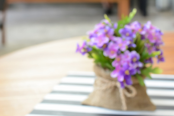 テーブルの上のジュート バッグに小さな紫の花 - 写真・画像